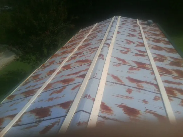 Rusted metal roof panels with new wood purlins before replacement — Storm Damage Roof Repair in Wilkesboro by Roofing Brothers