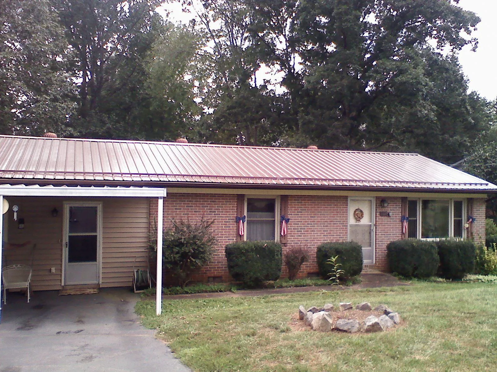 Bronze metal roof and carport on a brick ranch home — Roof Repair work by our crew in Wilkesboro